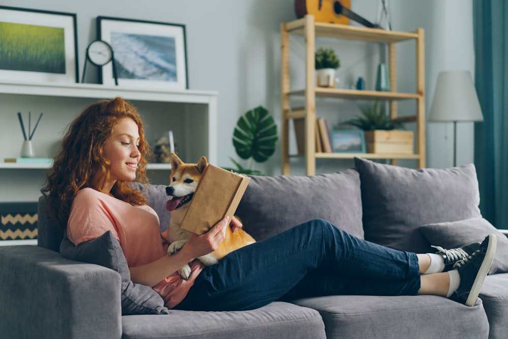 a woman sitting on a couch holding a dog