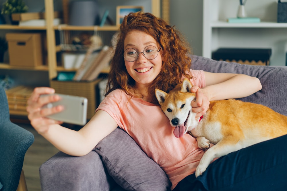 a woman sitting on a couch holding a dog