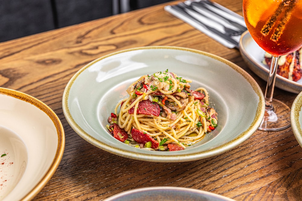 a plate of spaghetti and a glass of wine on a table