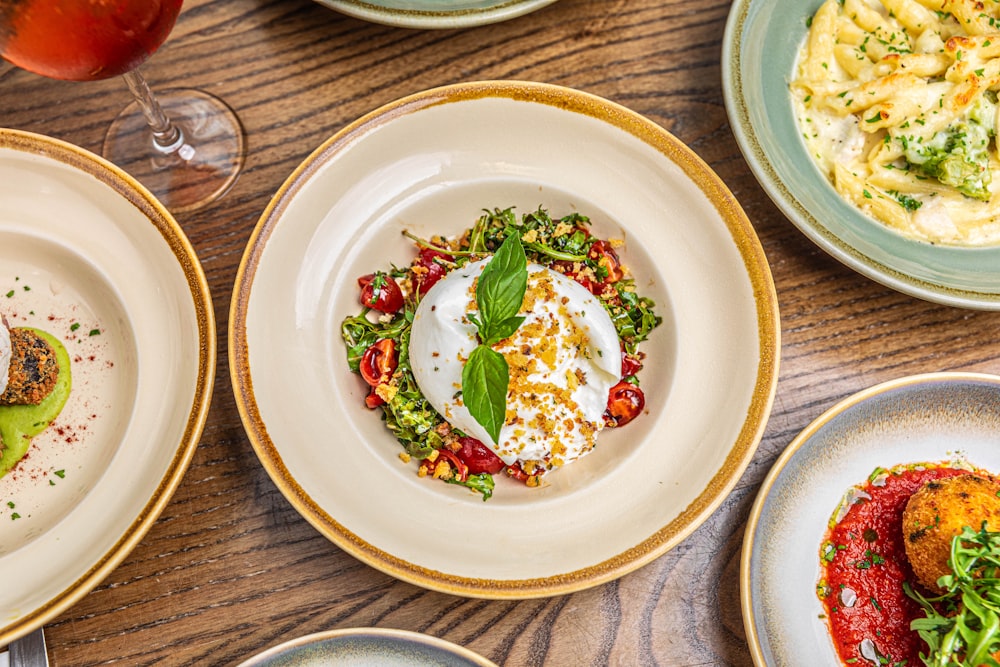 a table topped with plates of food and glasses of wine