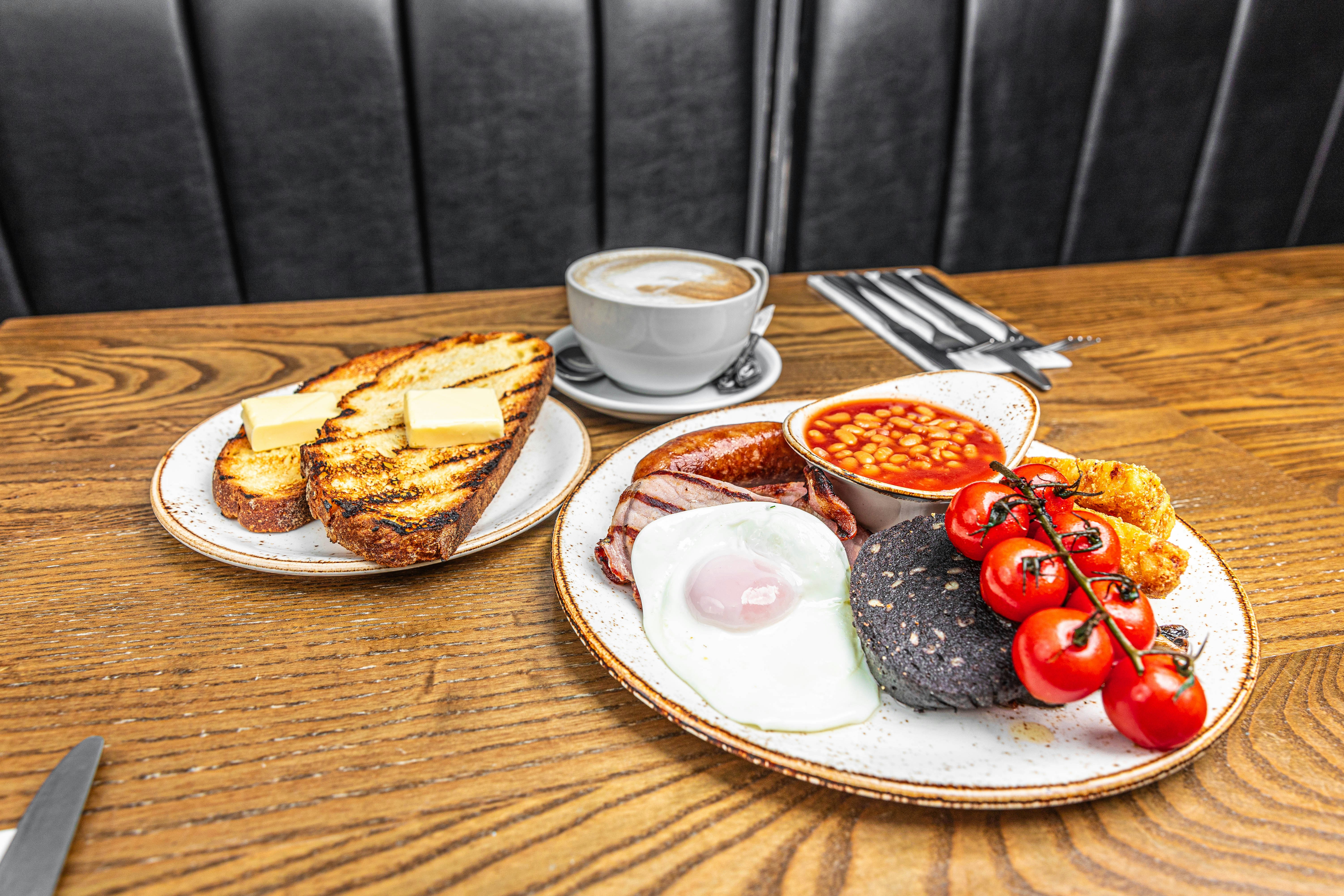 a table with a plate of food and a cup of coffee, 