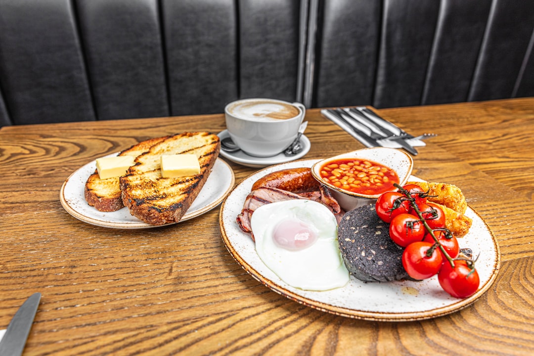 a table with a plate of food and a cup of coffee,