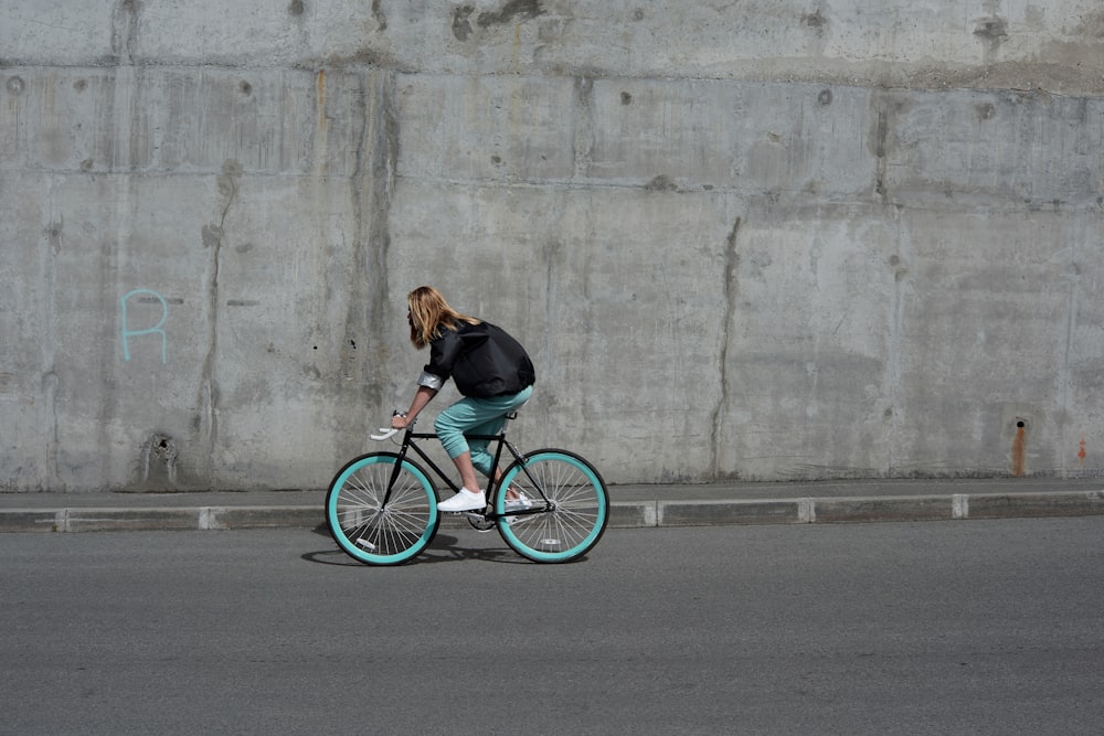 a woman riding a bike down a street