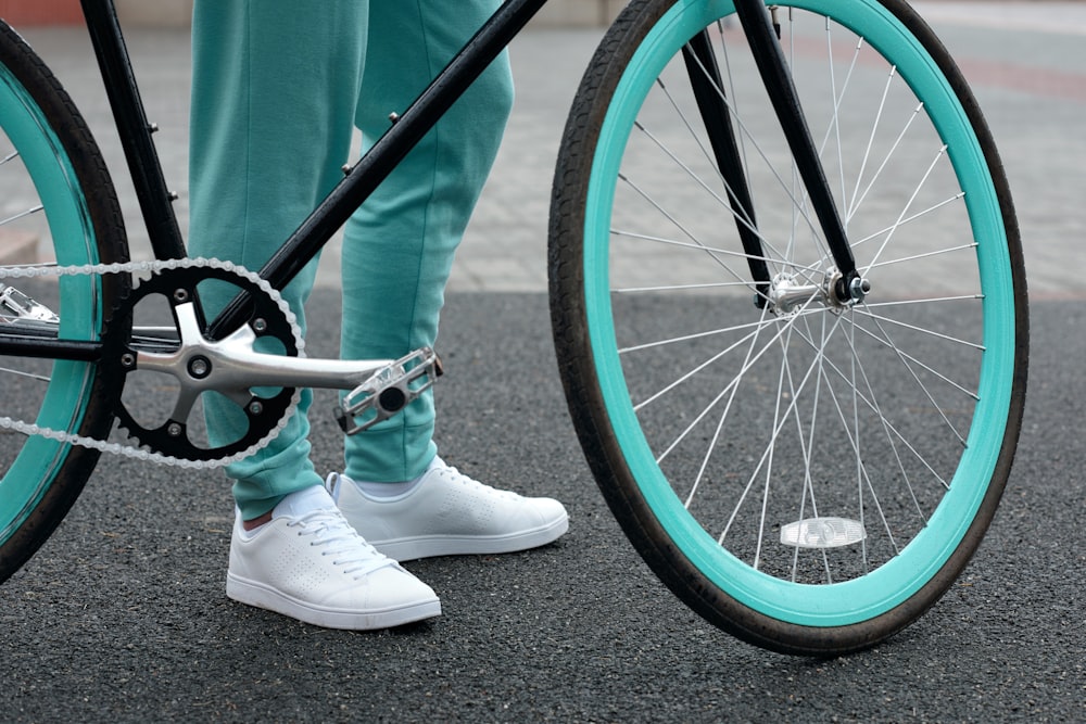 a person standing next to a blue bicycle