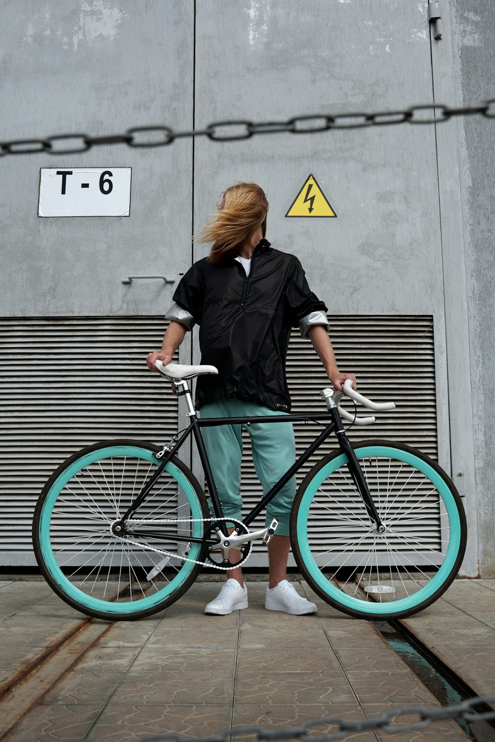 a woman standing next to a bike on a sidewalk