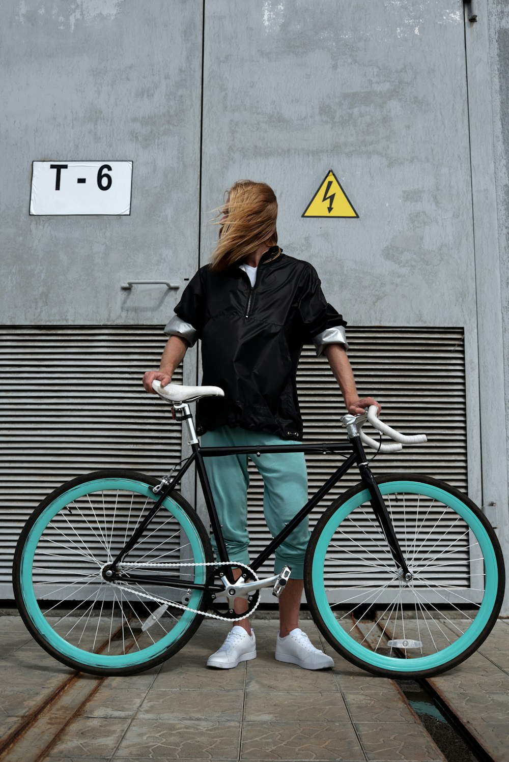a woman standing next to a bike on a sidewalk