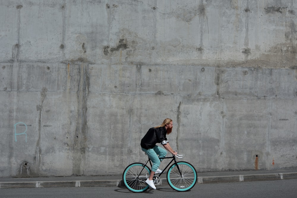 a woman riding a blue bike down a street