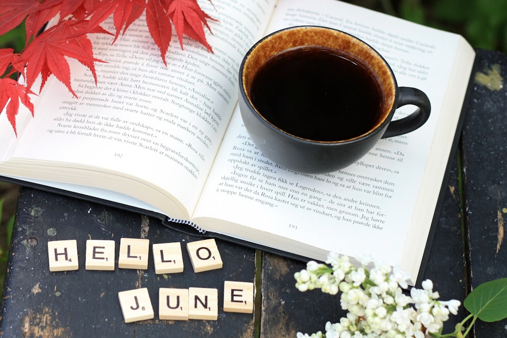 une tasse de café posée sur une table à côté d’un livre