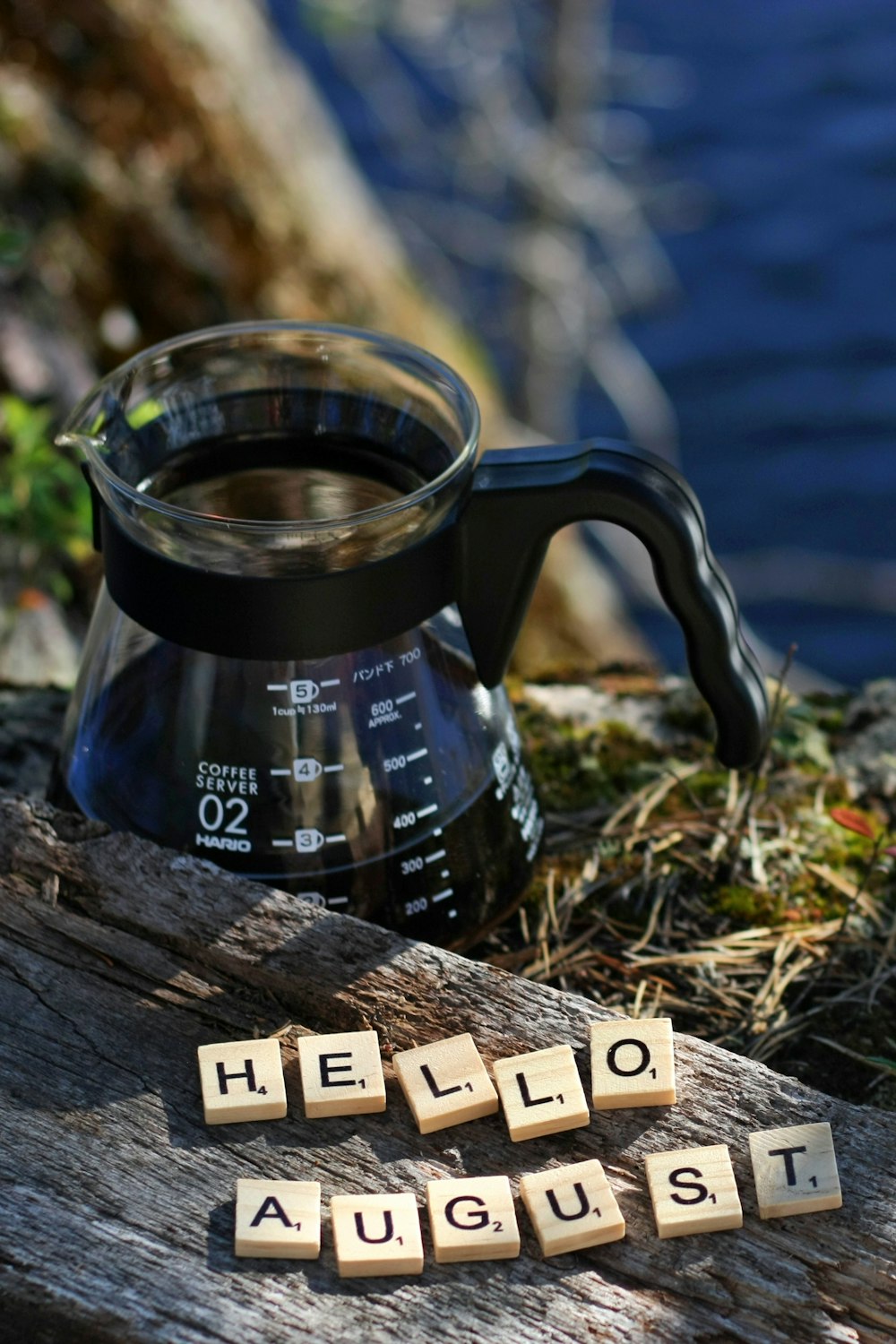 a coffee pot with scrabbles spelling hello august