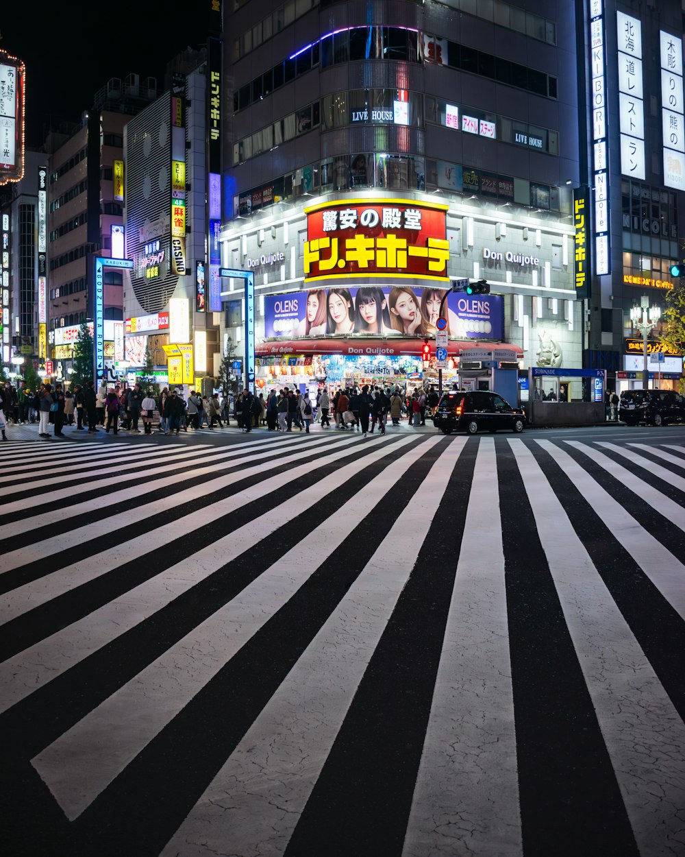 une rue de la ville la nuit avec beaucoup de monde