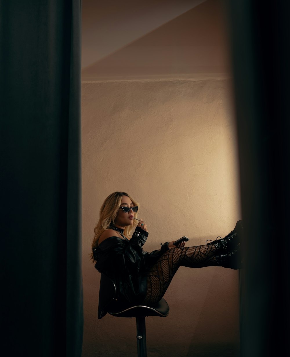 a woman sitting on top of a chair holding a camera