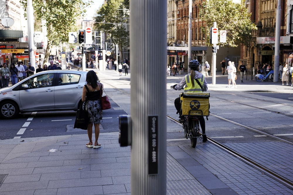 a man riding a bike down a street next to a traffic light
