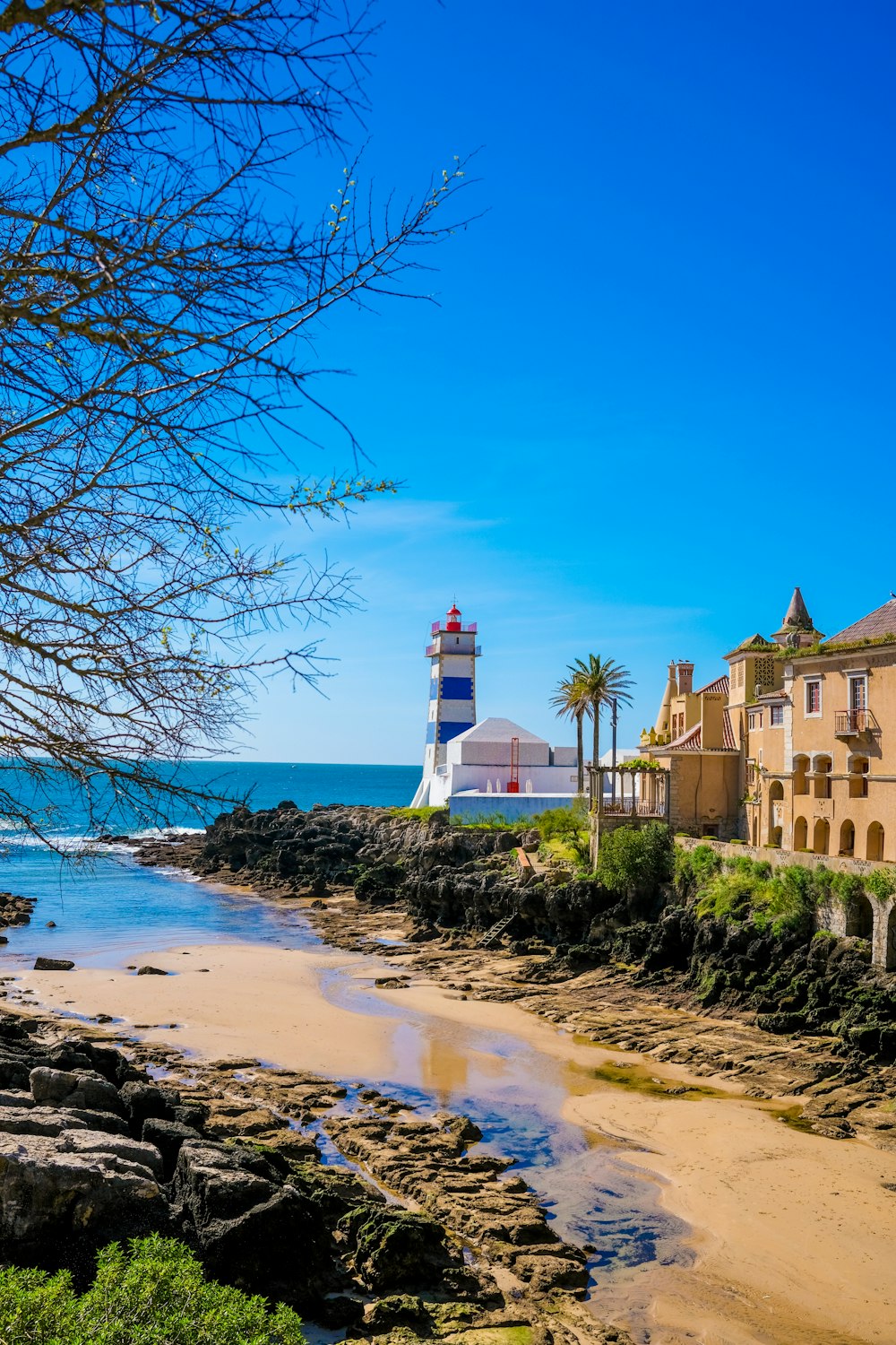 a light house sitting on top of a beach next to the ocean