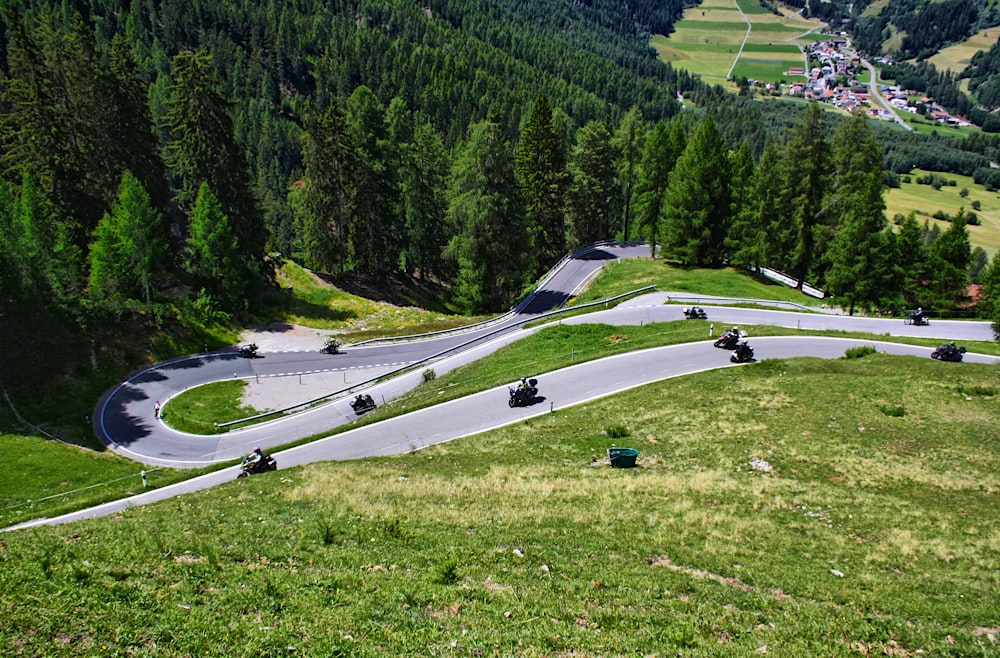 a group of cars driving down a curvy road