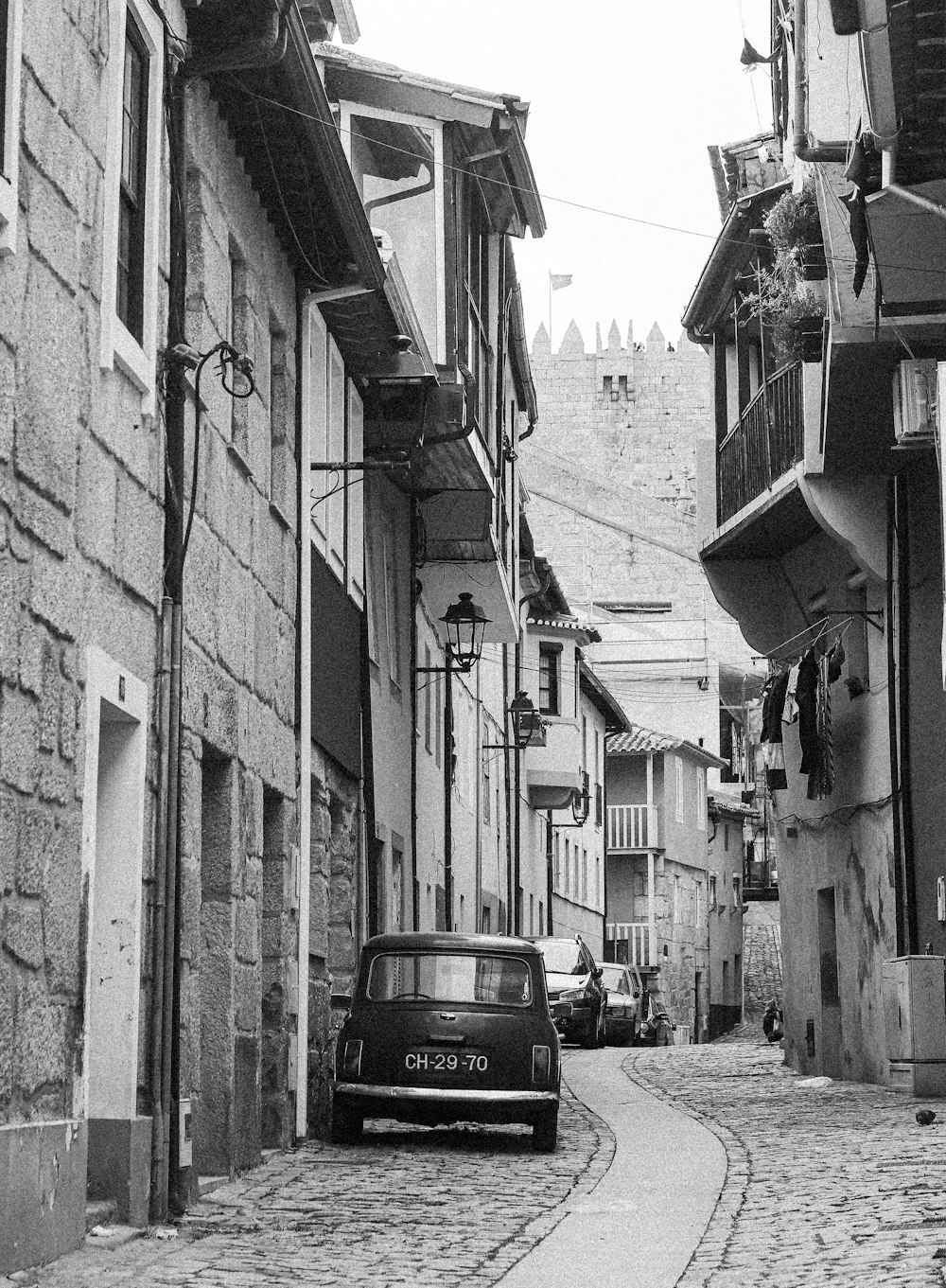 a car is parked on a cobblestone street