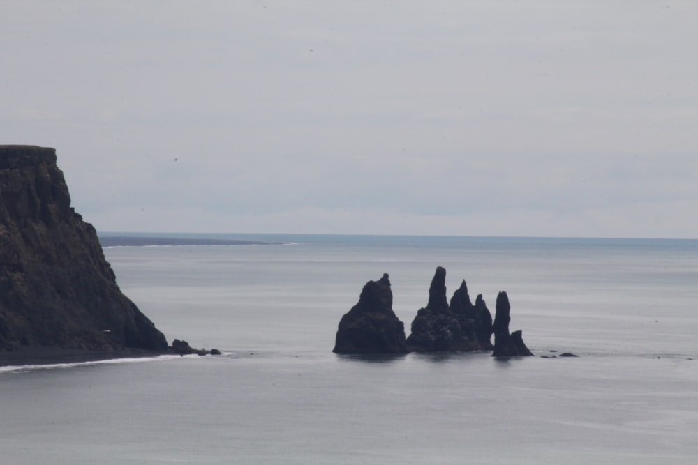 a group of rocks sticking out of the ocean