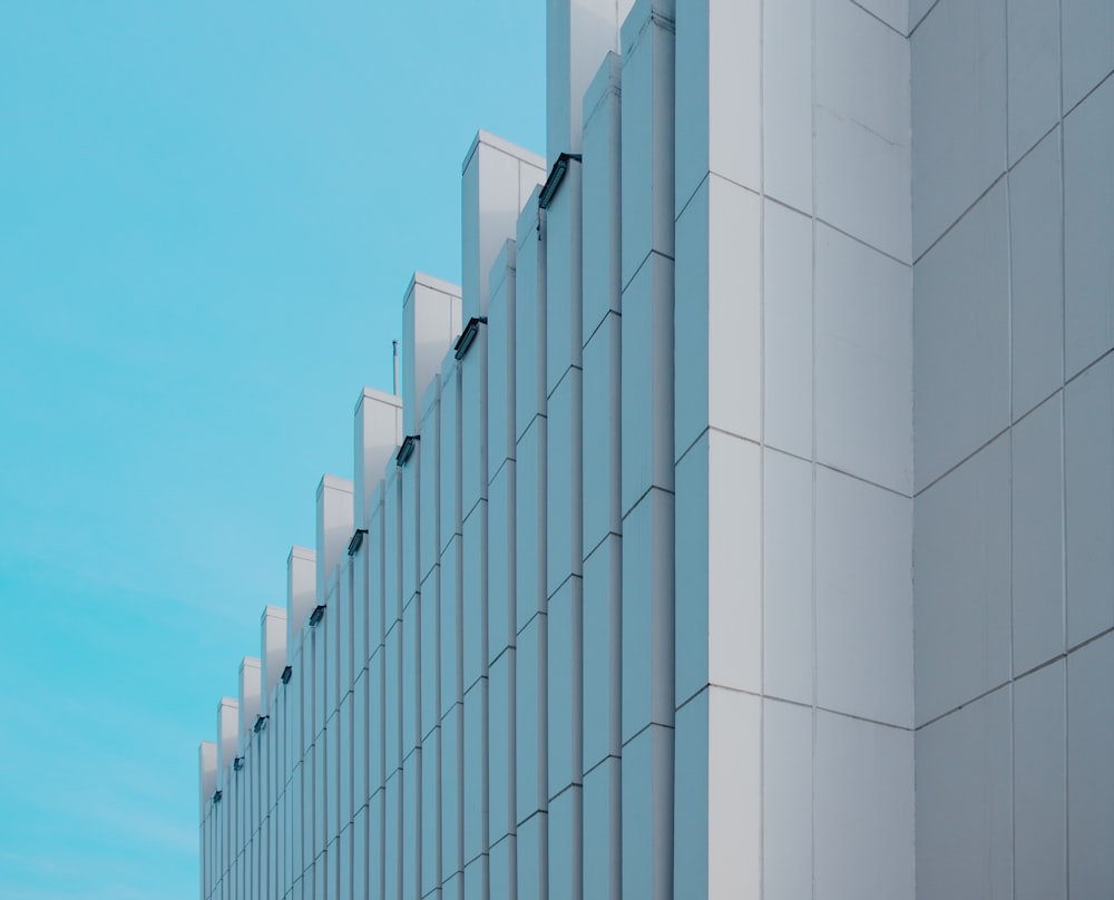 a tall white building sitting next to a blue sky