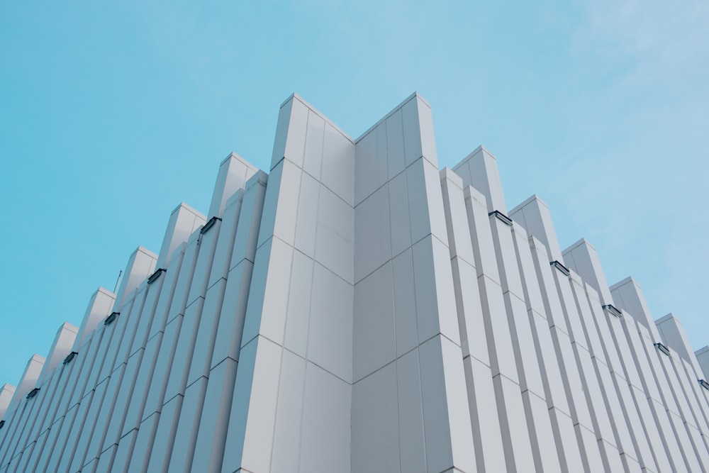 a tall white building with a blue sky in the background