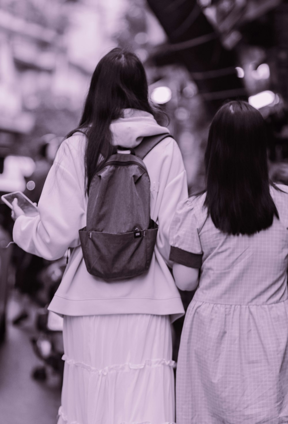 two women walking down a street holding hands