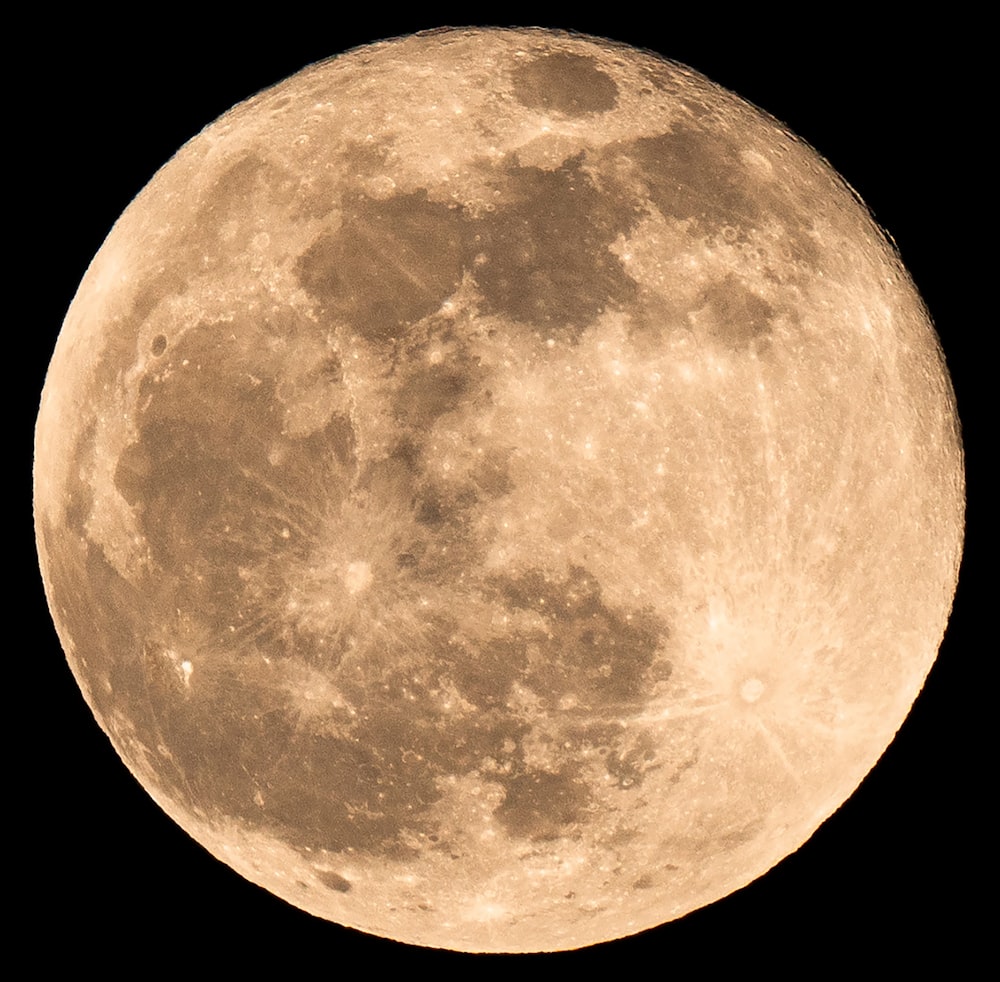 a full moon is shown in the dark sky