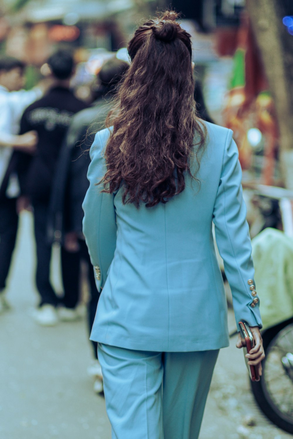 a woman in a blue suit walking down a street