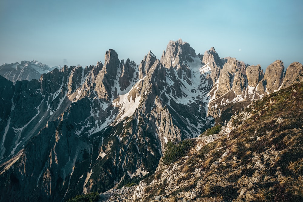 a view of a mountain range from the top of a hill