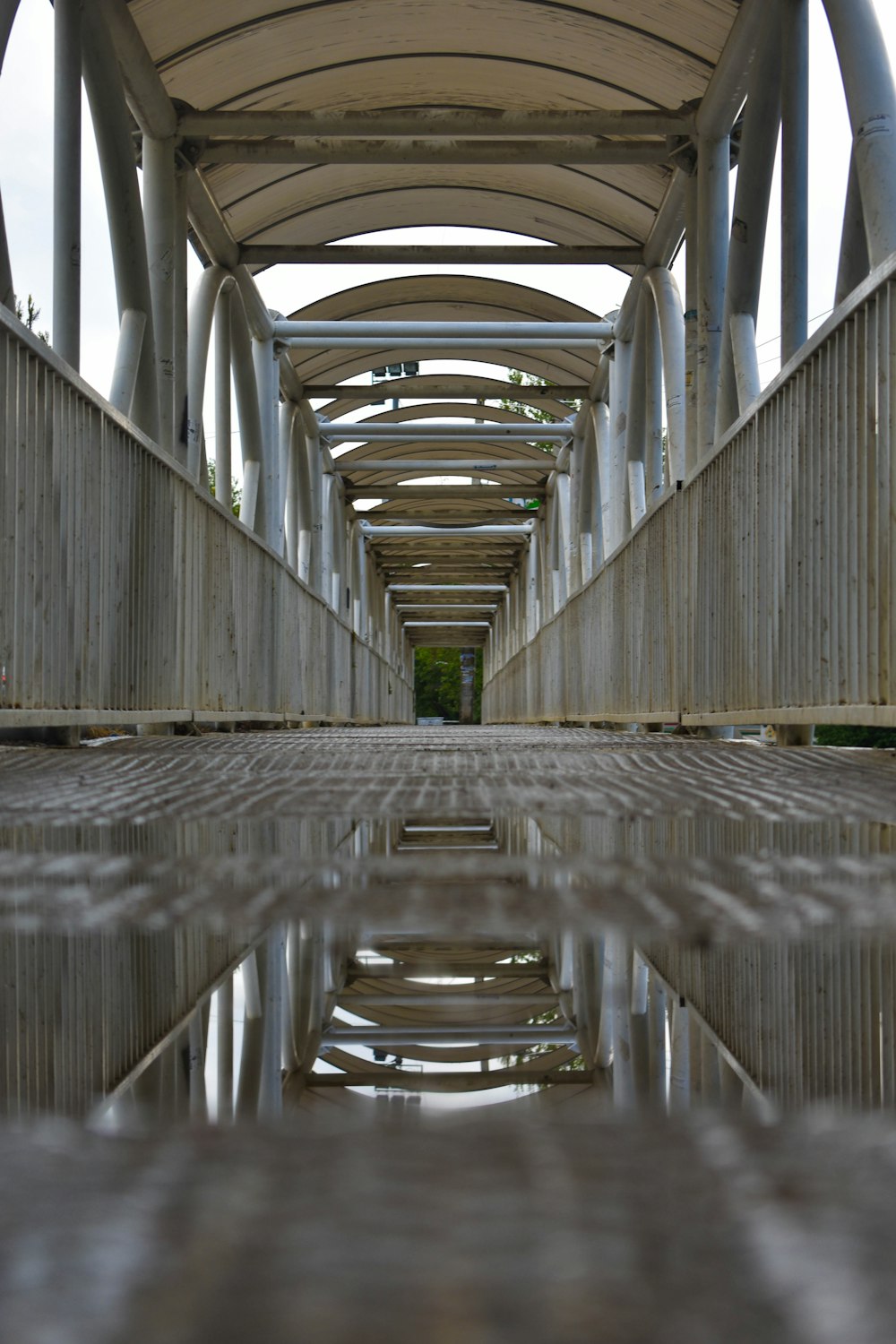 a bridge with a reflection of the sky in the water