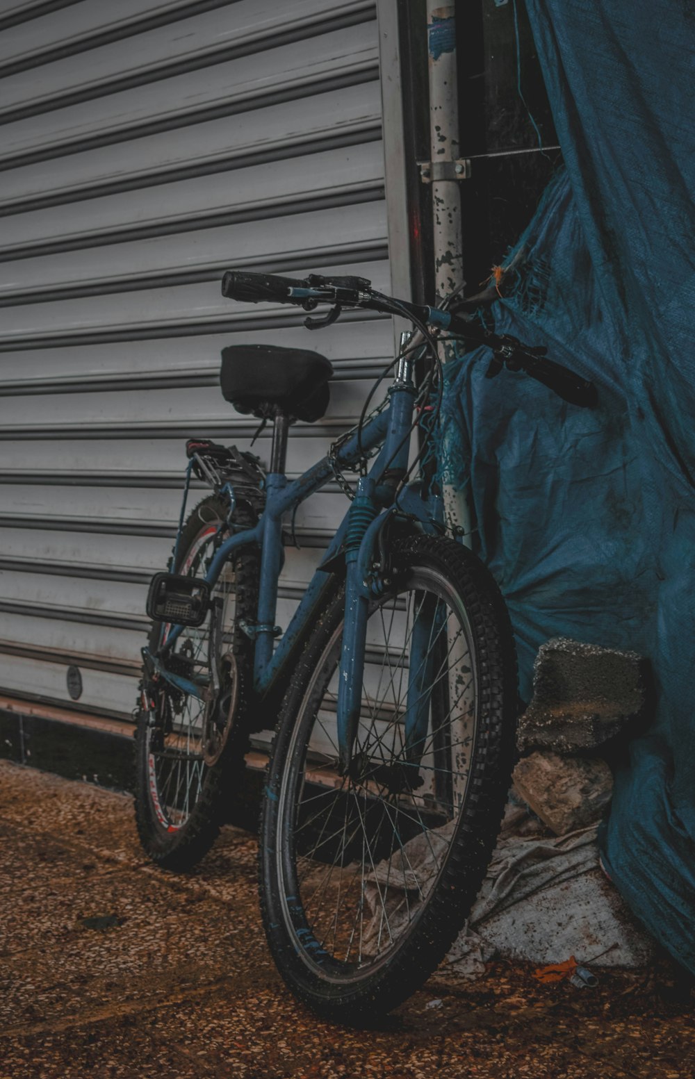 a blue bike is parked next to a building