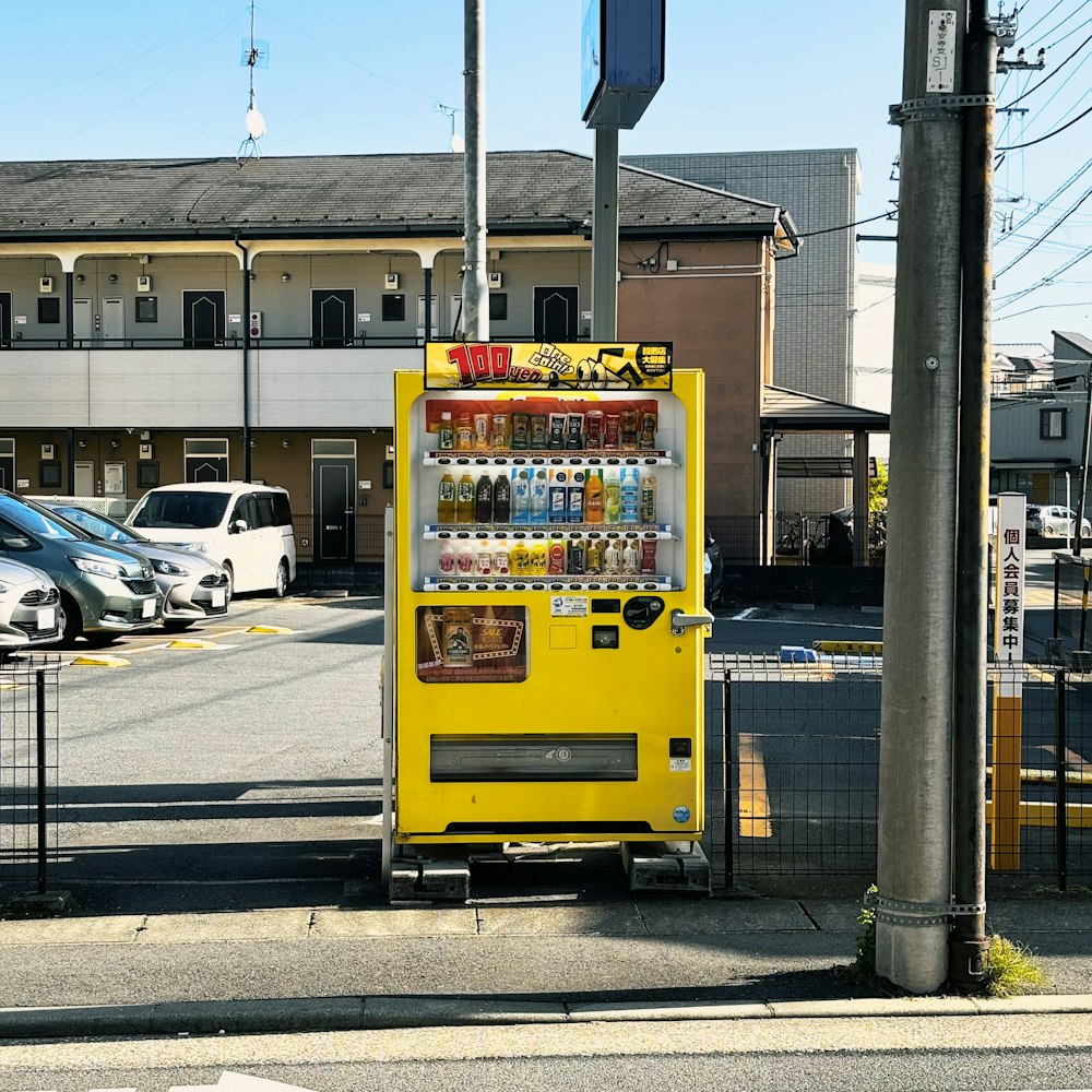 a yellow vending machine sitting on the side of a road