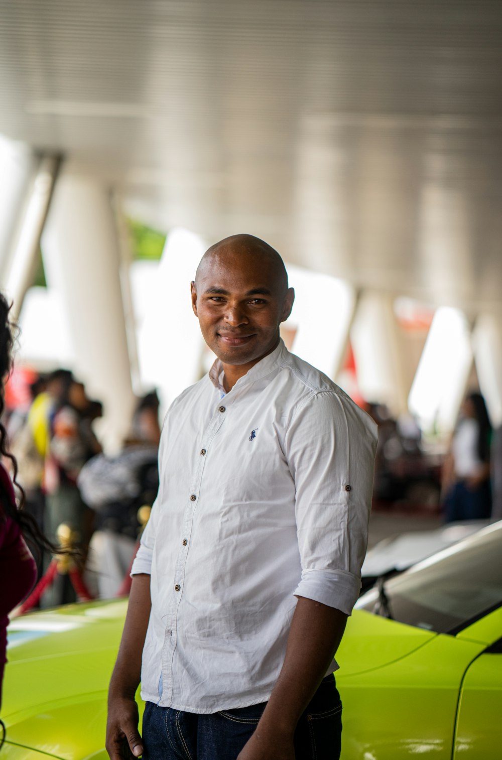 a man standing next to a green sports car