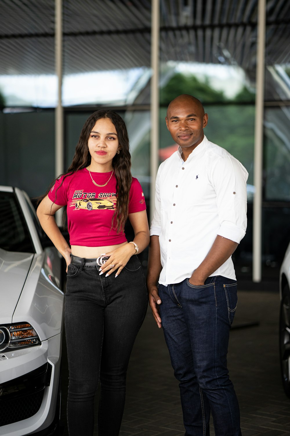 a man and a woman standing next to a car