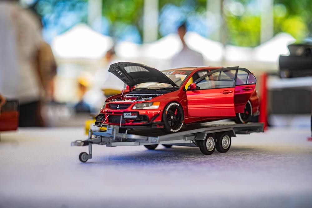a toy car on a trailer with the hood open