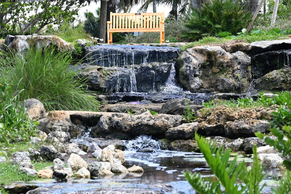 a wooden bench sitting on top of a lush green hillside