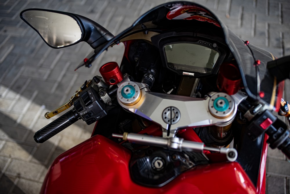 a close up of a red motorcycle with a clock