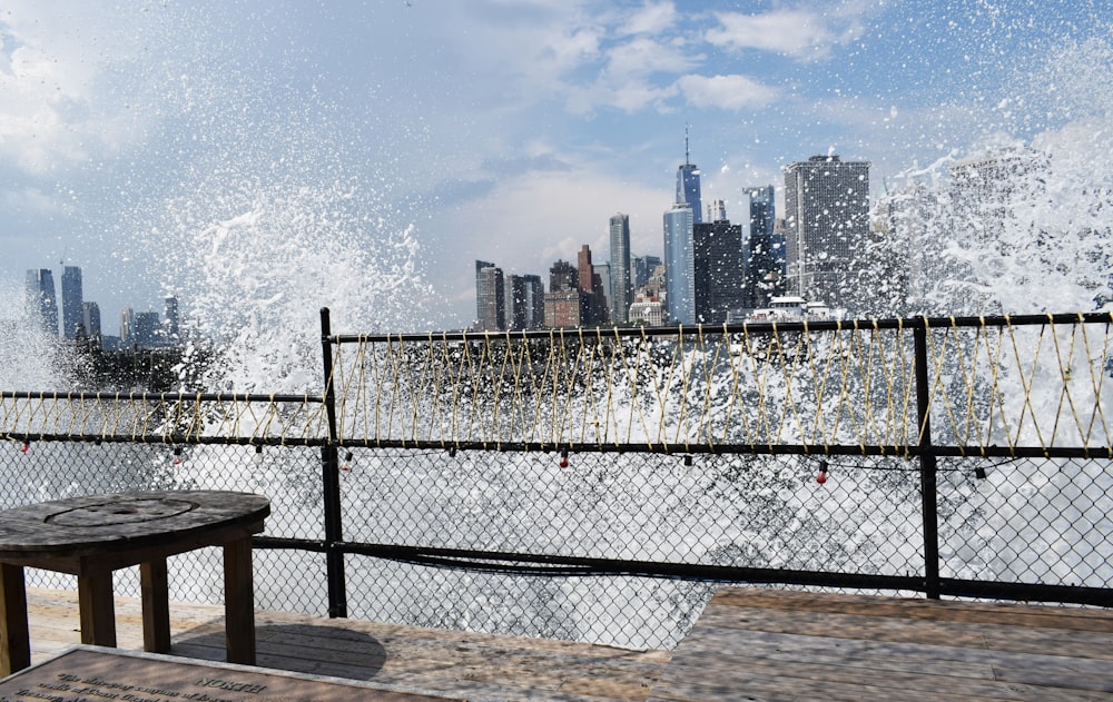a view of a large wave crashing over a fence