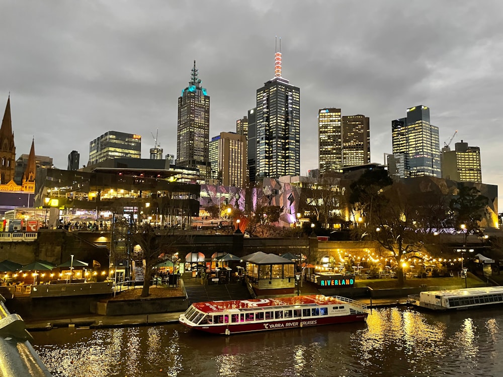 a boat floating on top of a river next to tall buildings