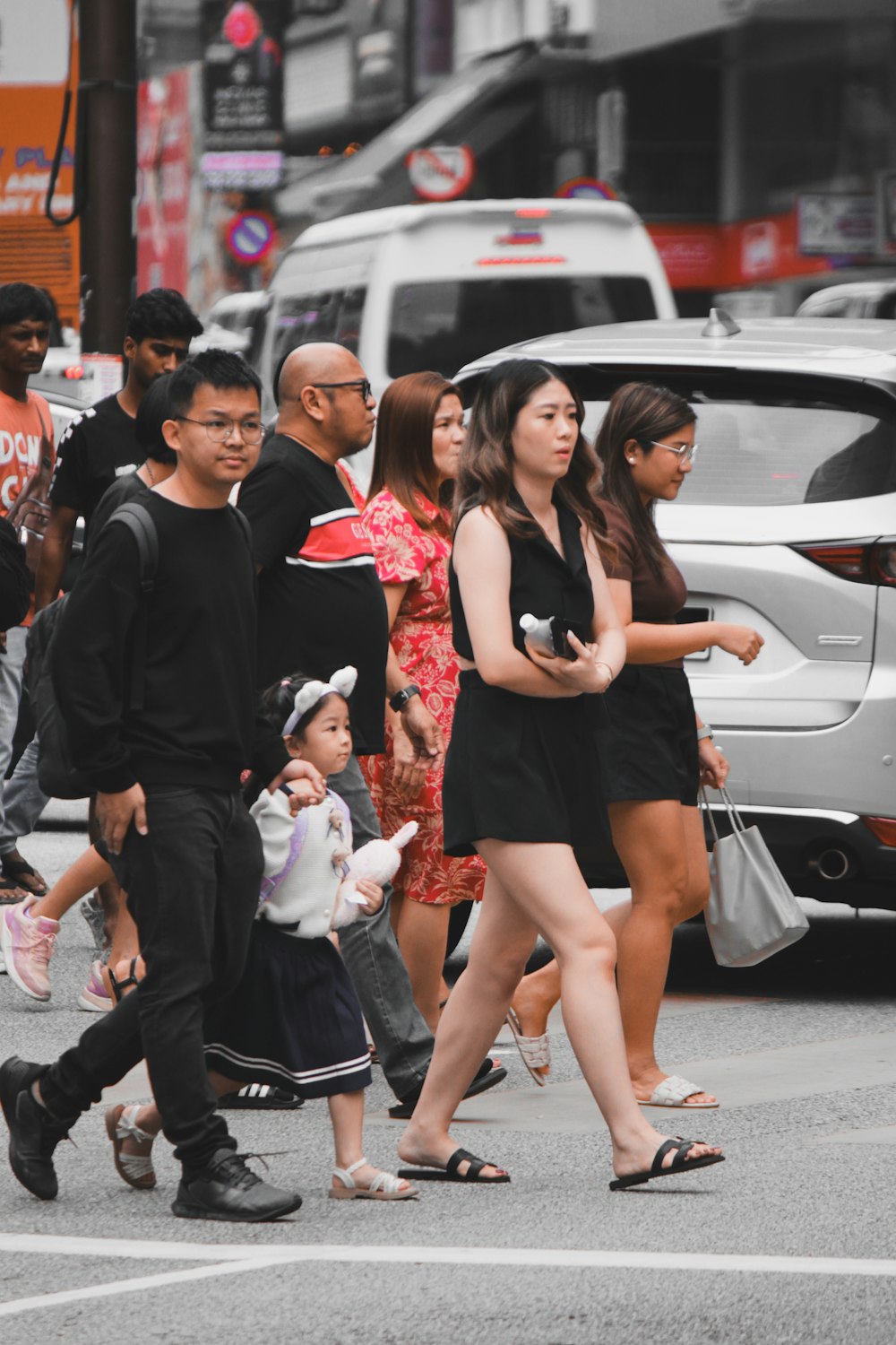 a group of people walking across a street