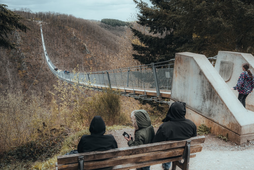 a group of people sitting on top of a wooden bench