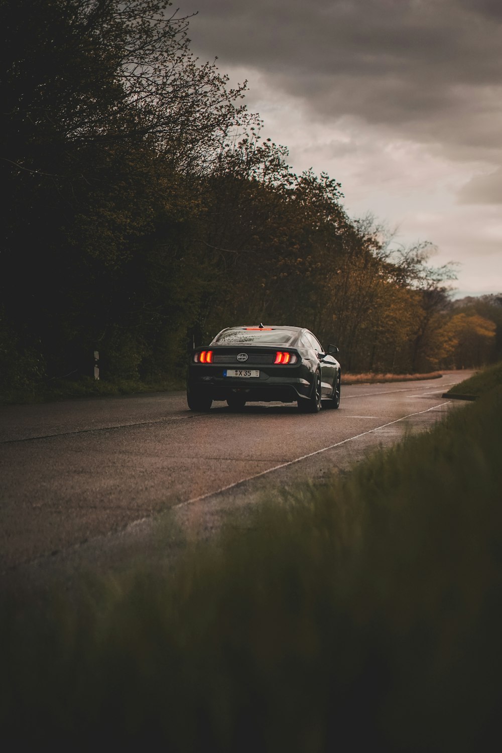 a black sports car driving down a country road
