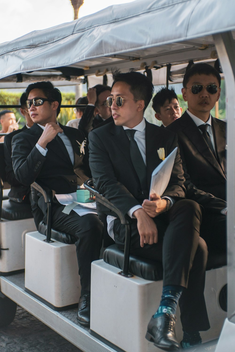 Eine Gruppe von Männern in Anzügen, die auf einem Golfwagen sitzen