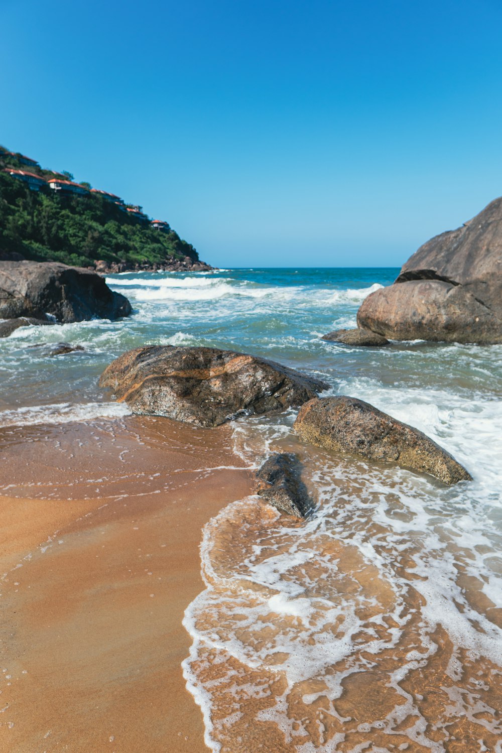 a sandy beach with waves coming in to shore