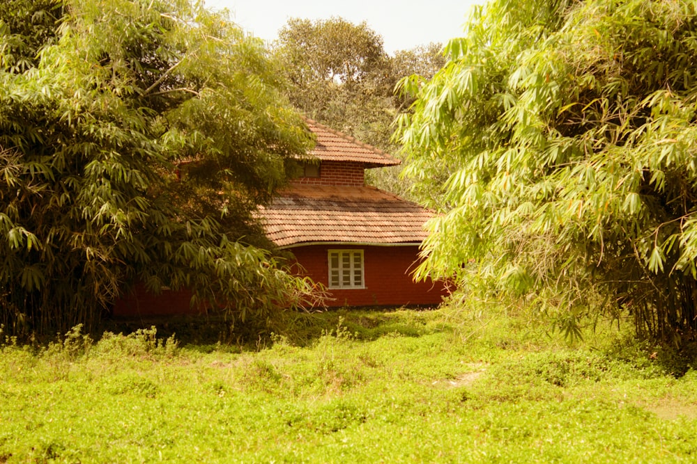 a small red house surrounded by trees and grass