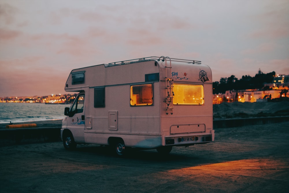 a white bus parked next to a body of water