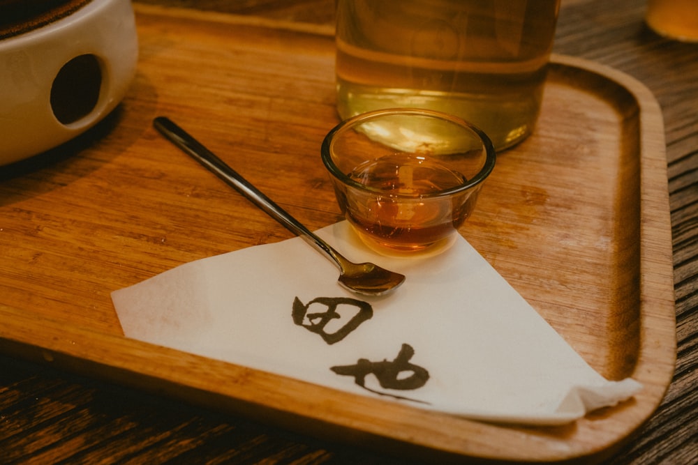 a glass of tea and a spoon on a tray