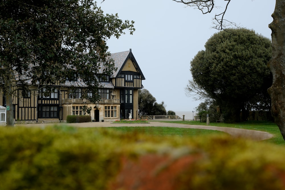 a large house sitting on top of a lush green field