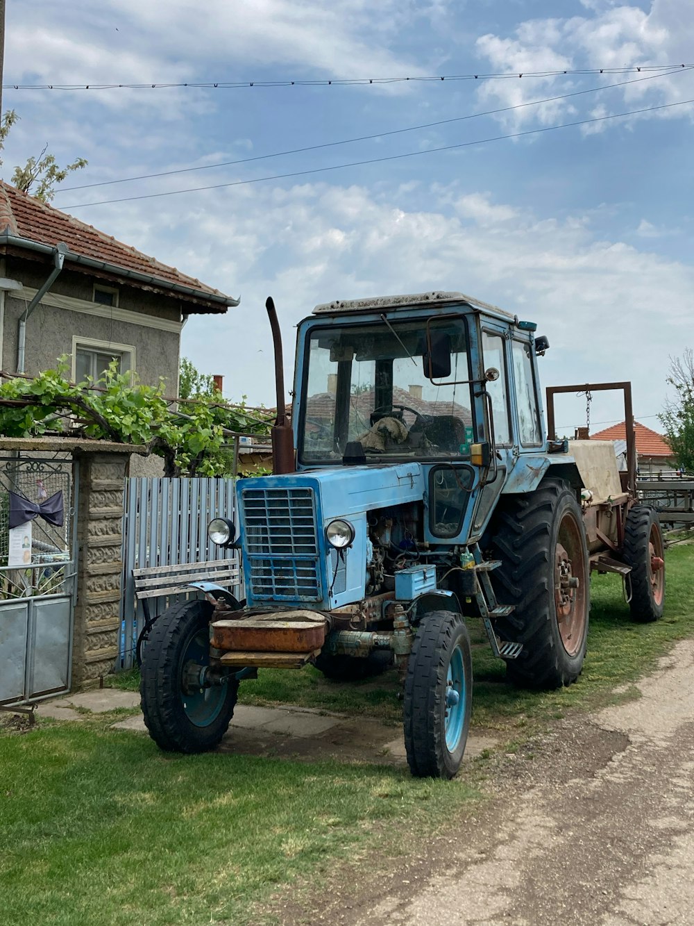 a blue tractor parked in front of a house