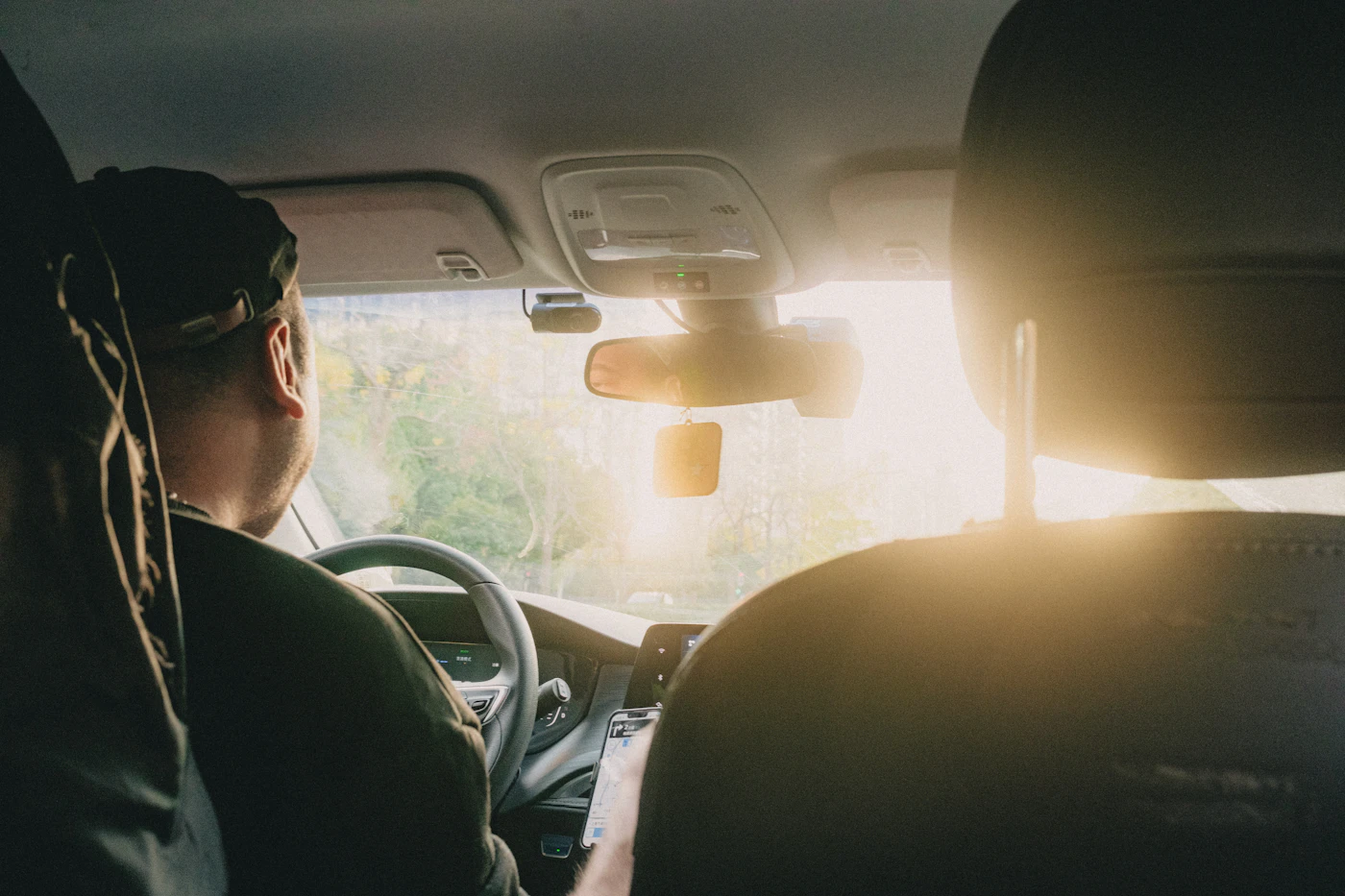 A man driving with sunlight coming through the windscreen