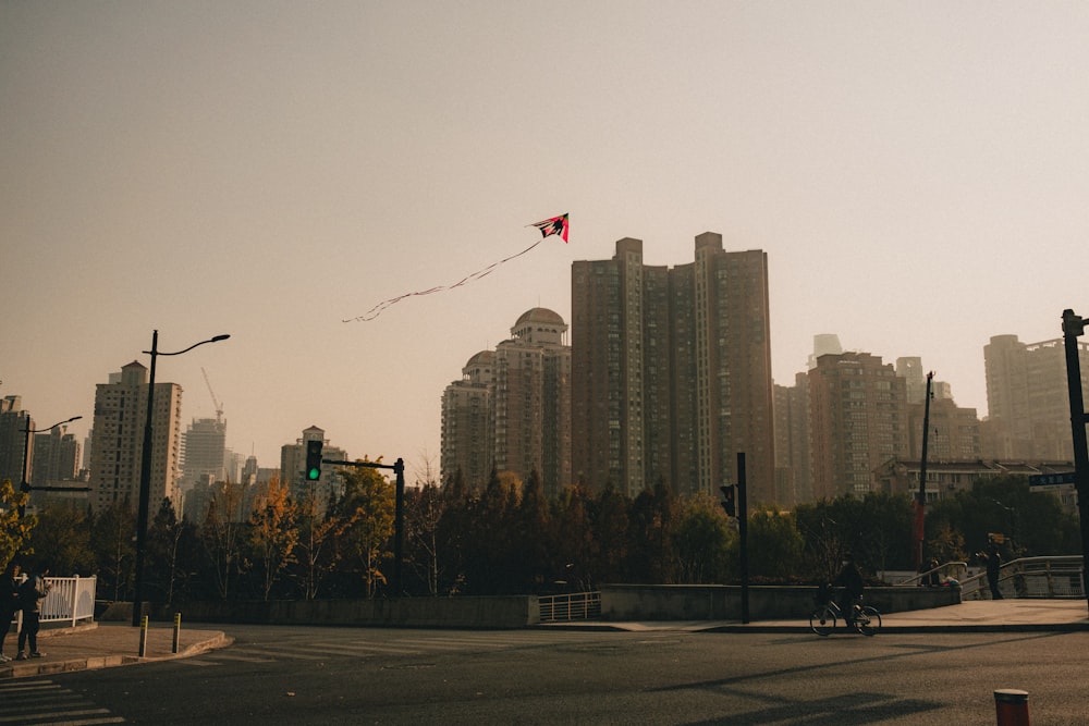 a kite flying in the air over a city street