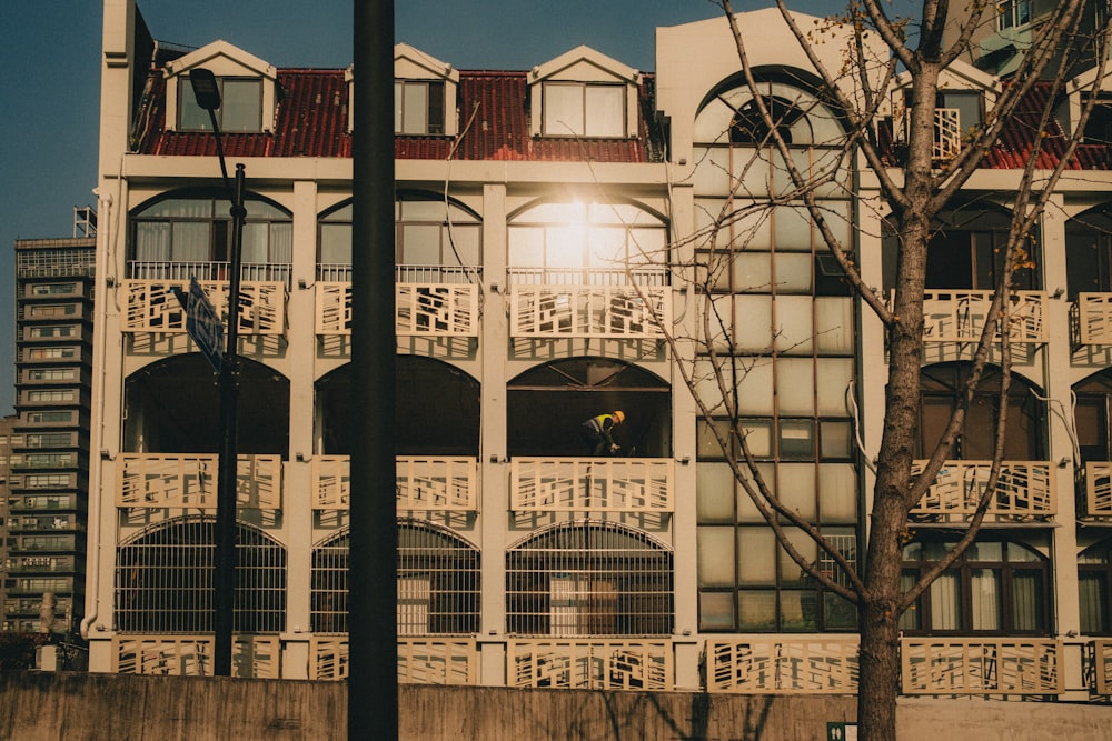 a tall white building sitting next to a tree