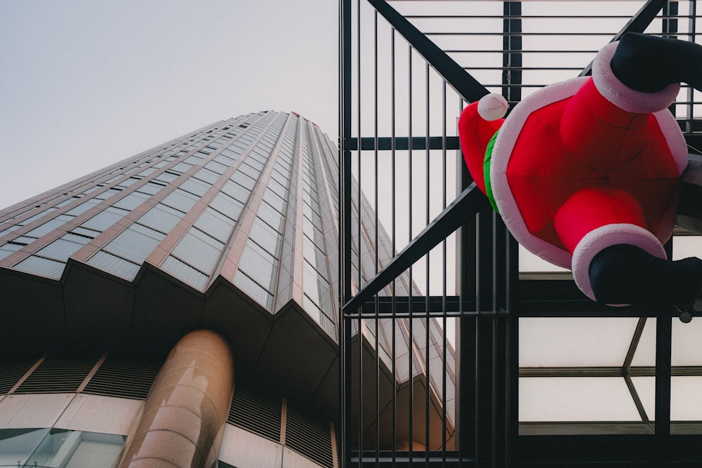 a large teddy bear sitting on top of a metal fence